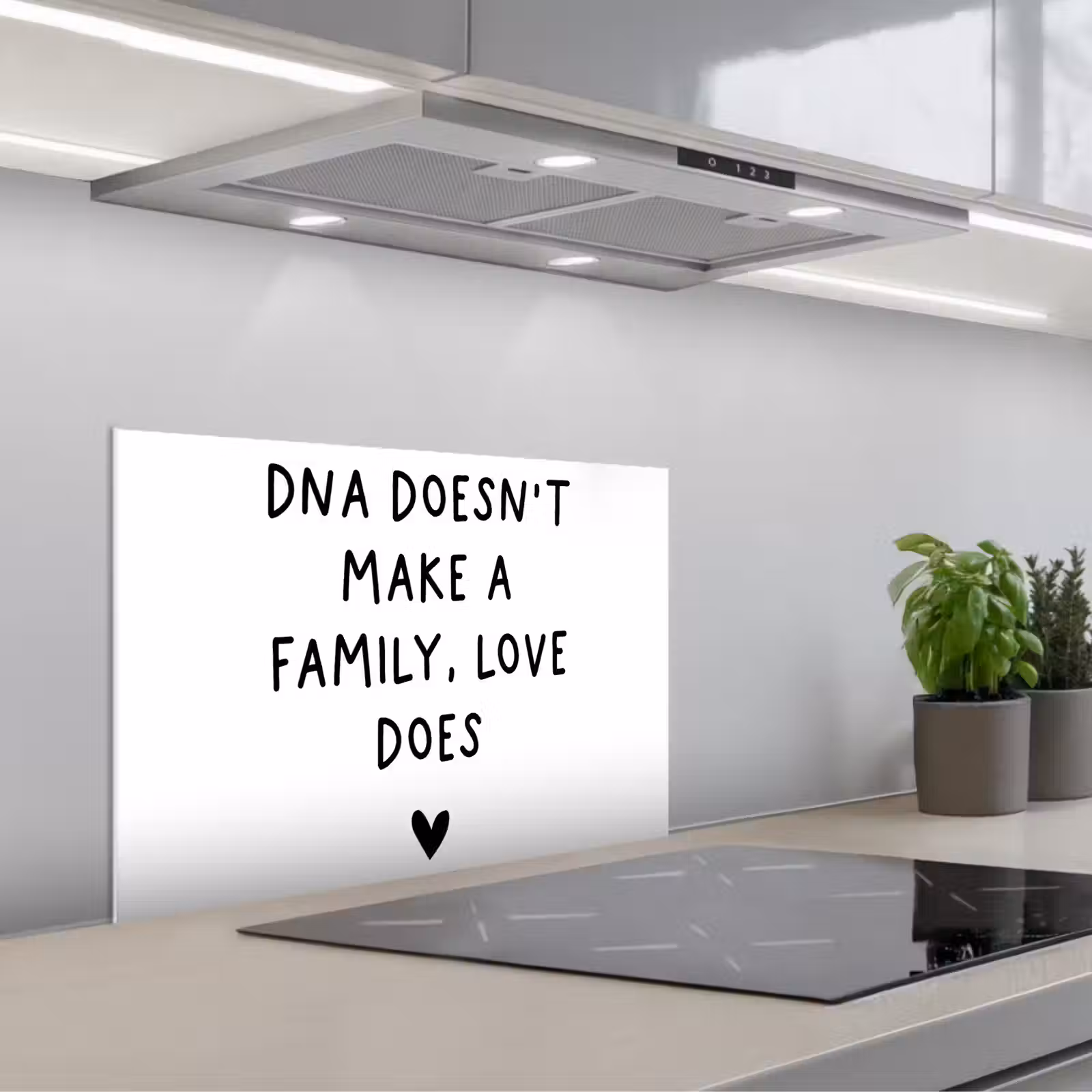 Salpicaderos de cocina - Cita en inglés "DNA doesn't make a family, love does" con un corazón sobre fondo blanco — 1