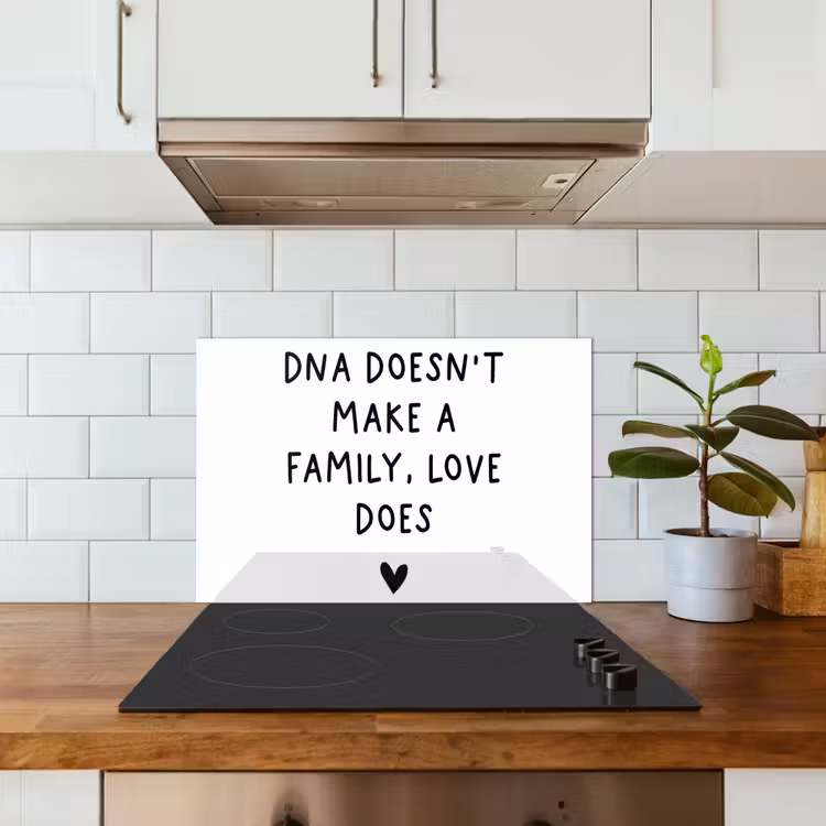 Salpicaderos de cocina - Cita en inglés "DNA doesn't make a family, love does" con un corazón sobre fondo blanco — 3