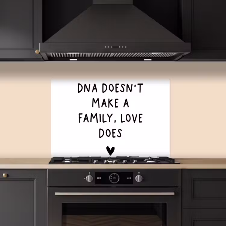 Salpicaderos de cocina - Cita en inglés "DNA doesn't make a family, love does" con un corazón sobre fondo blanco — 5